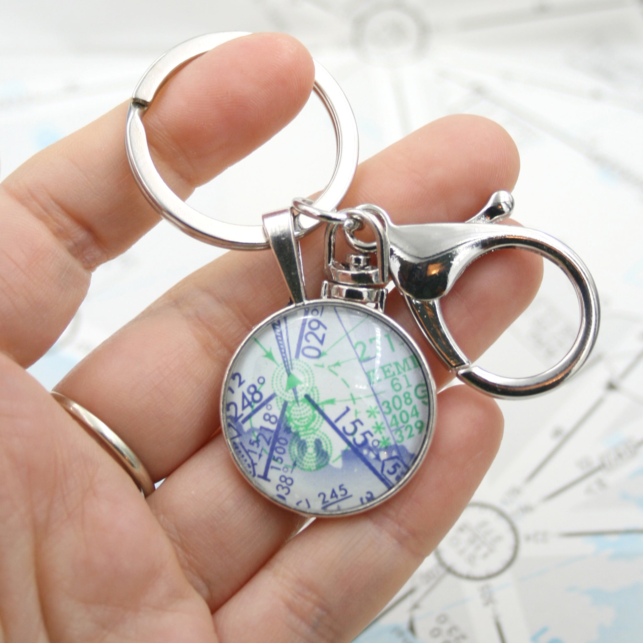 Hold in hand round, silver keychain featuring aeronautical chart 