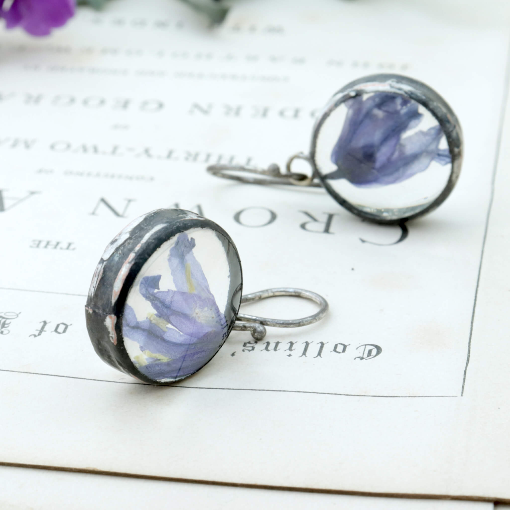 Earrings with real bluebells lying on an old photograph