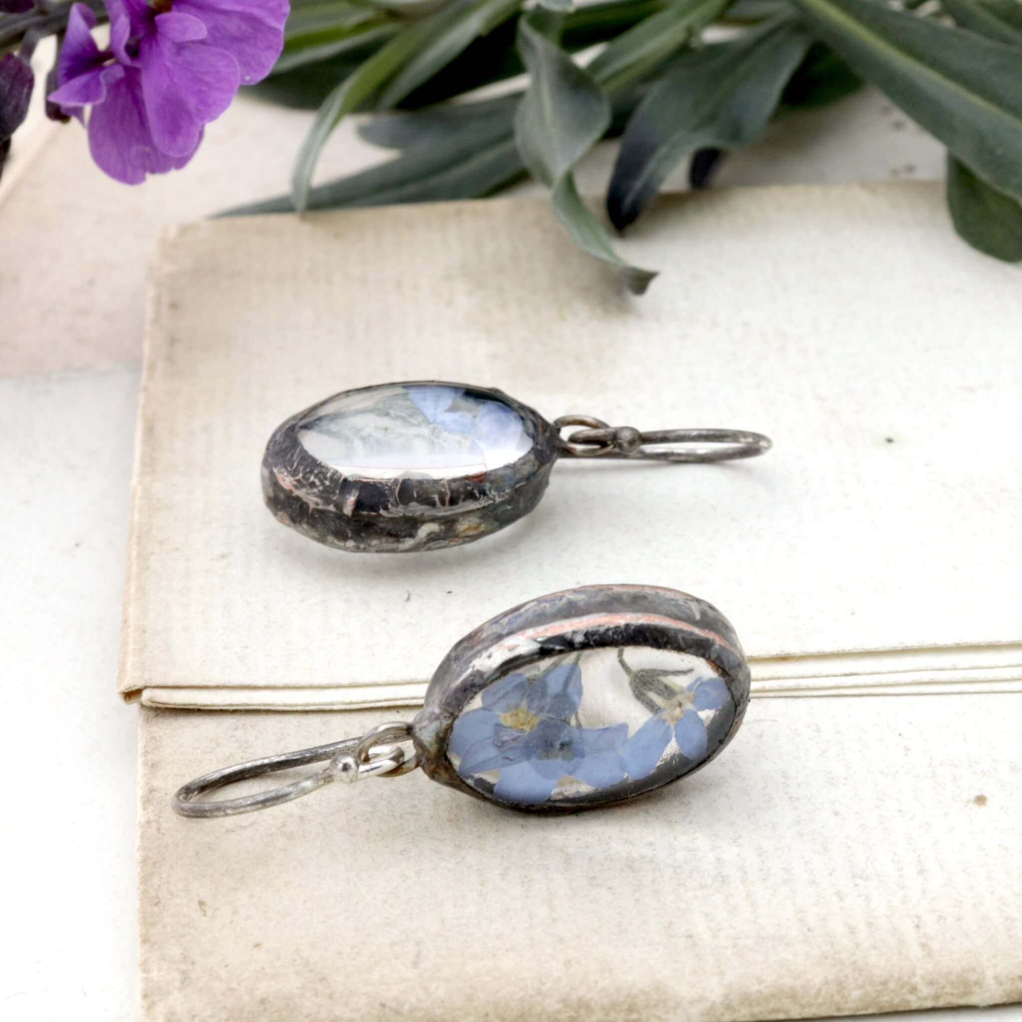Earrings with real forget-me-nots lying on an old letter