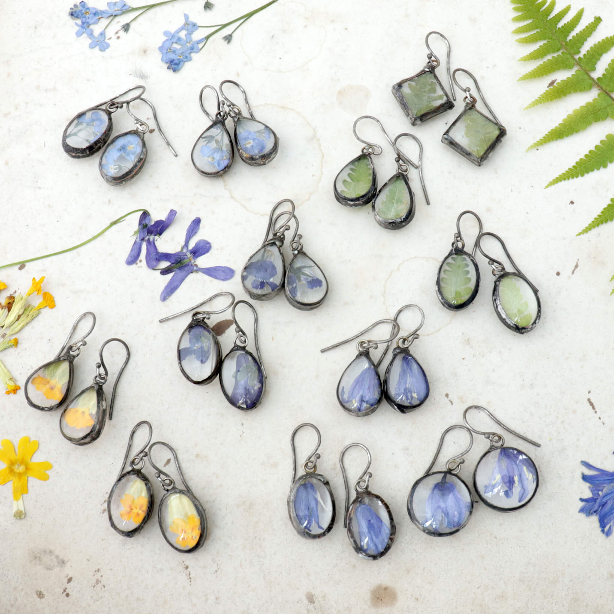 12 sets of colorful earrings with yellow, blue, violet and green flowers and plants