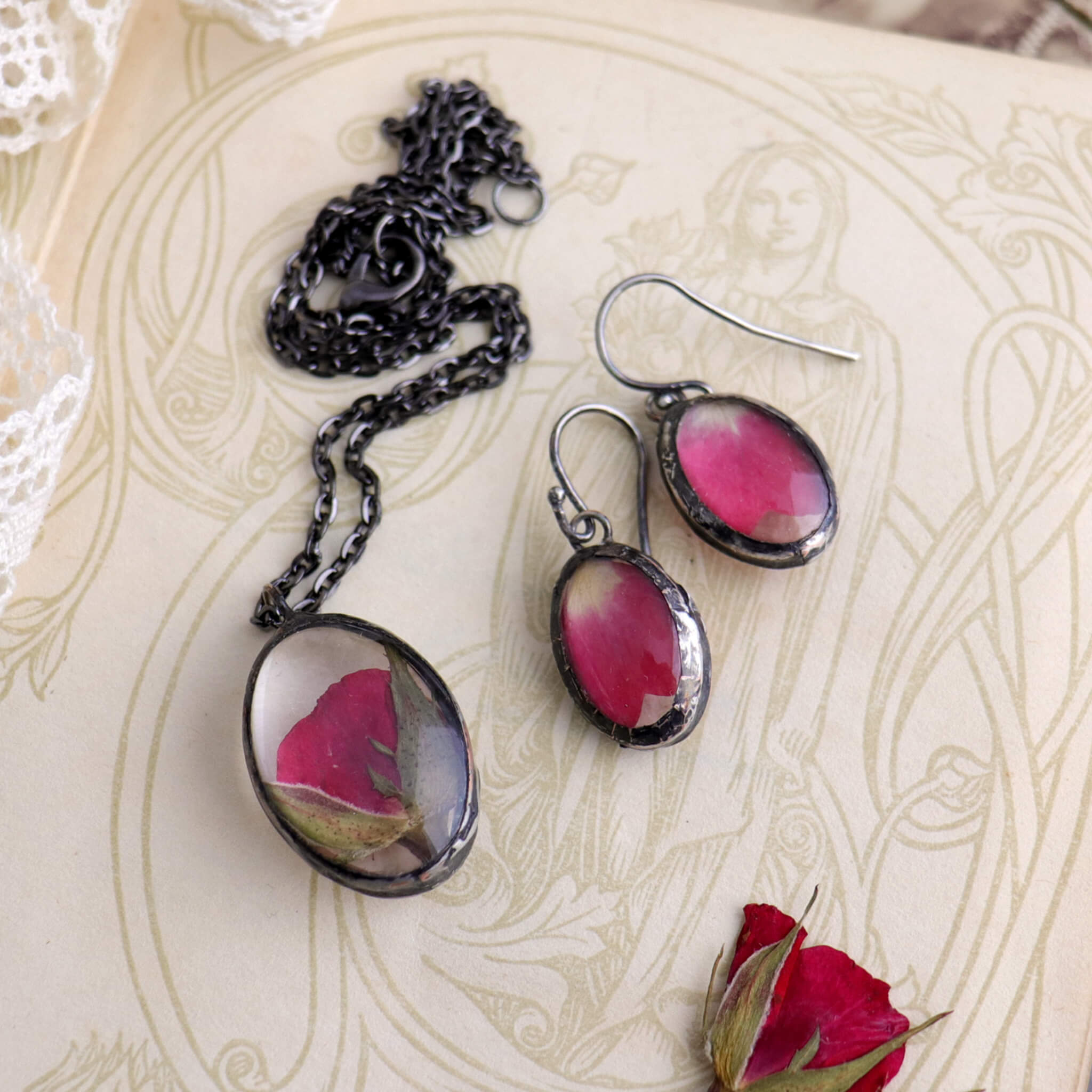Rose petal necklace and earrings lying on an old book