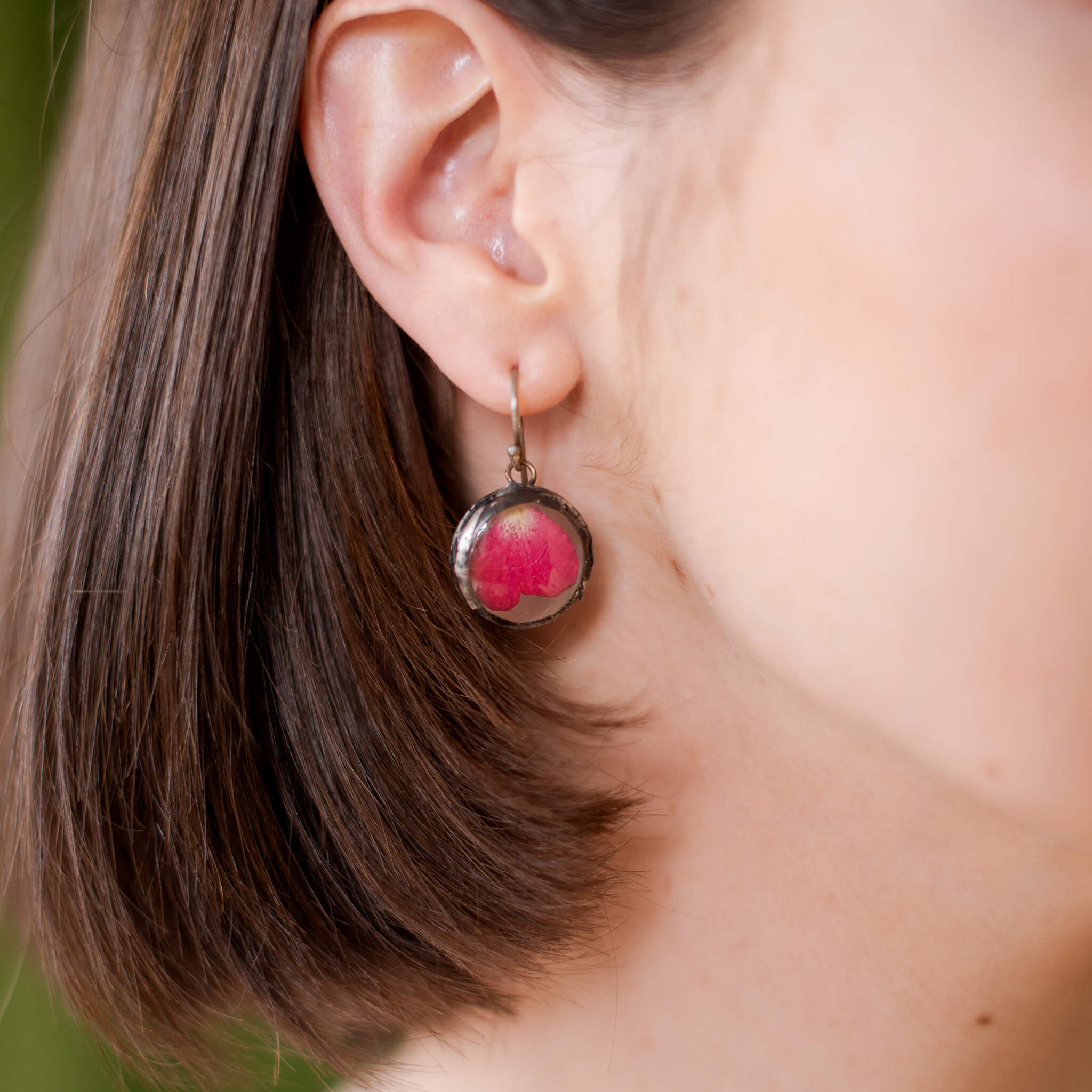 Brunette head zoom showing hair, ear and rose petal earrings