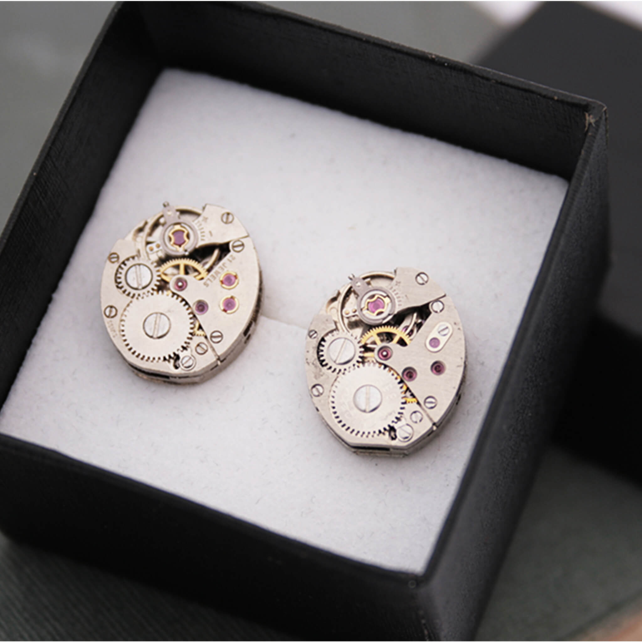 watch movements turned into stud earrings in a black presentation box
