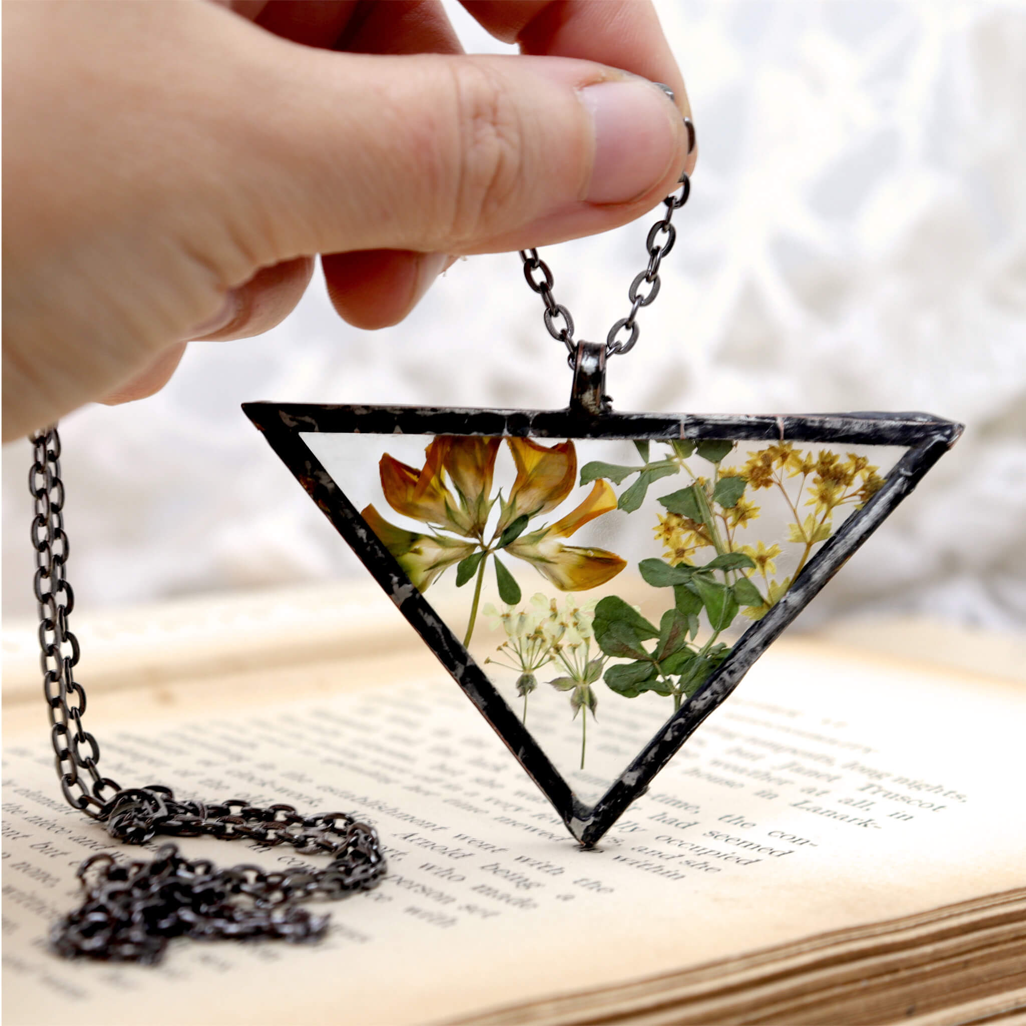Necklace of a mix of pressed flowers in triangular soldered glass