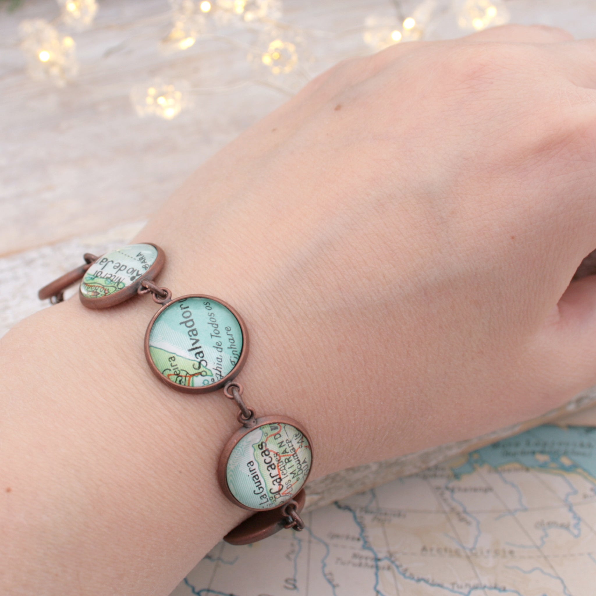 Worn on hand antique copper beaded bracelet featuring different map locations